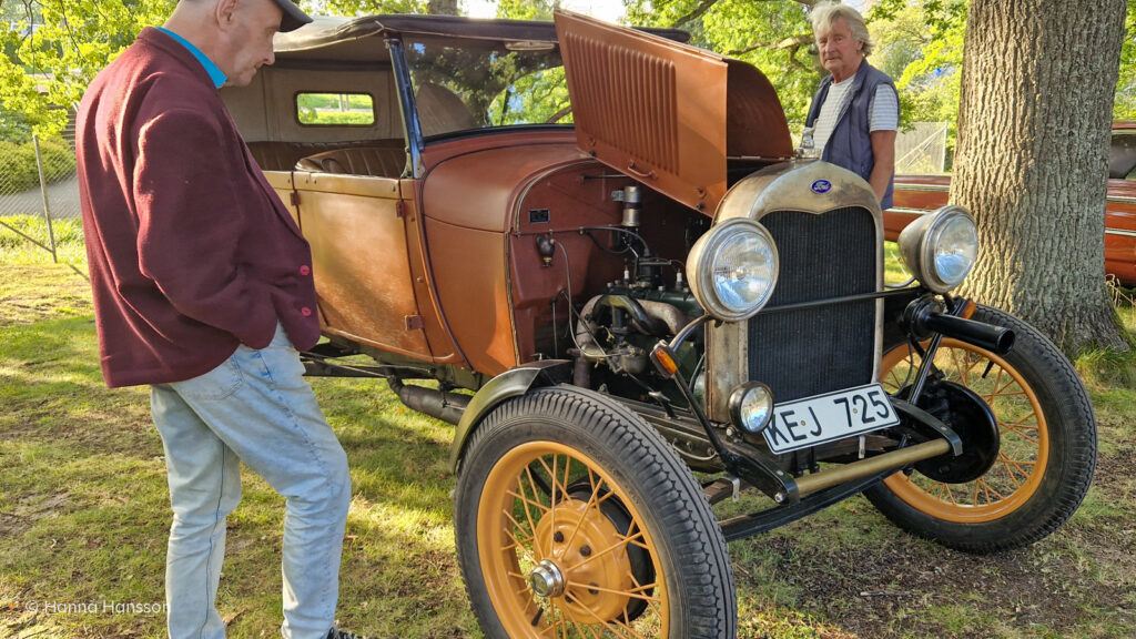 En röd Ford Model A veteranbil parkerad på Huskvarna Folkets Park.