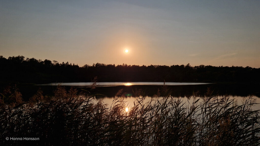 Solen går ned över sjön vid Kinnekulle stenbrott.