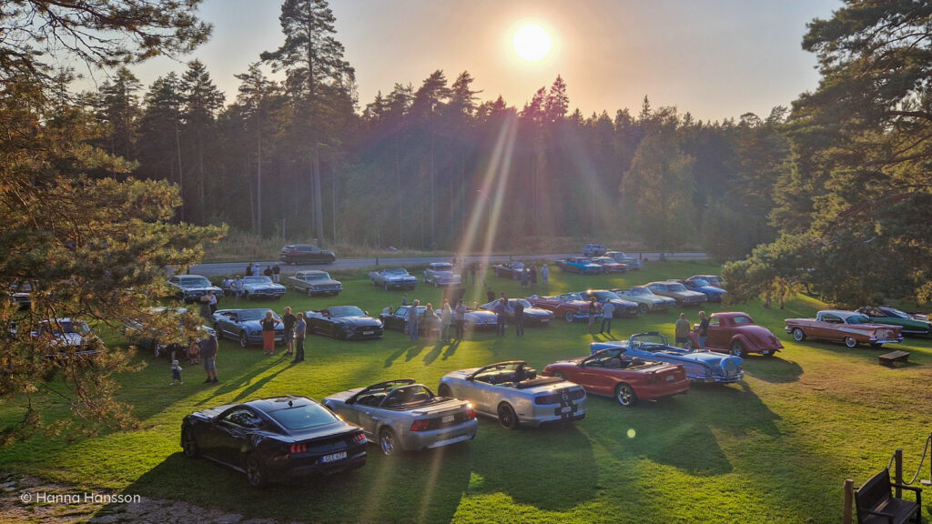 Bilar uppställda på bilträff utanför Mullsjö Hotell, sedd från hotellets balkong.